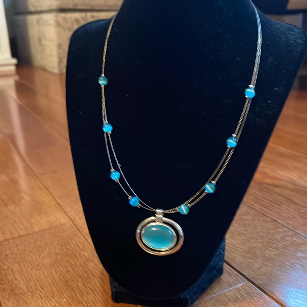 Silver necklace with aqua colored beads and pendant.